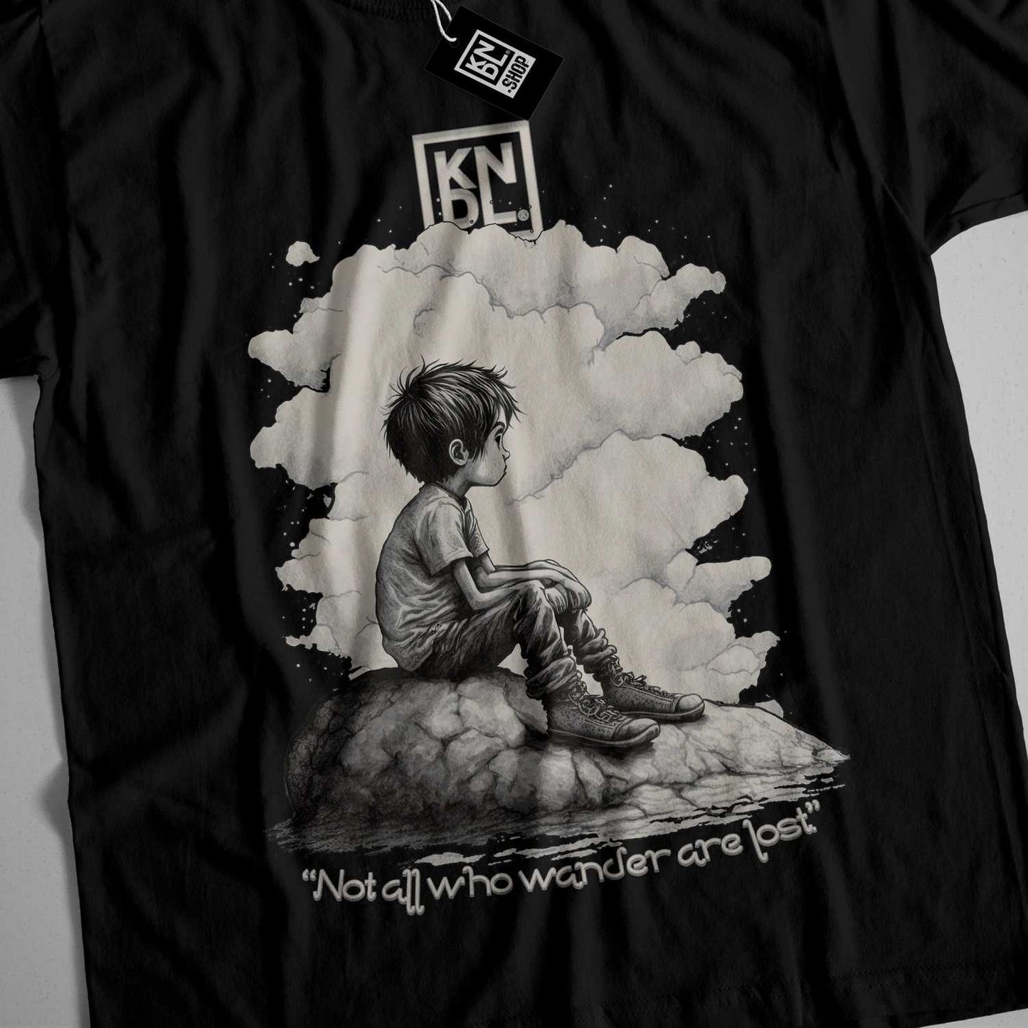 a black shirt with a picture of a boy sitting on a rock