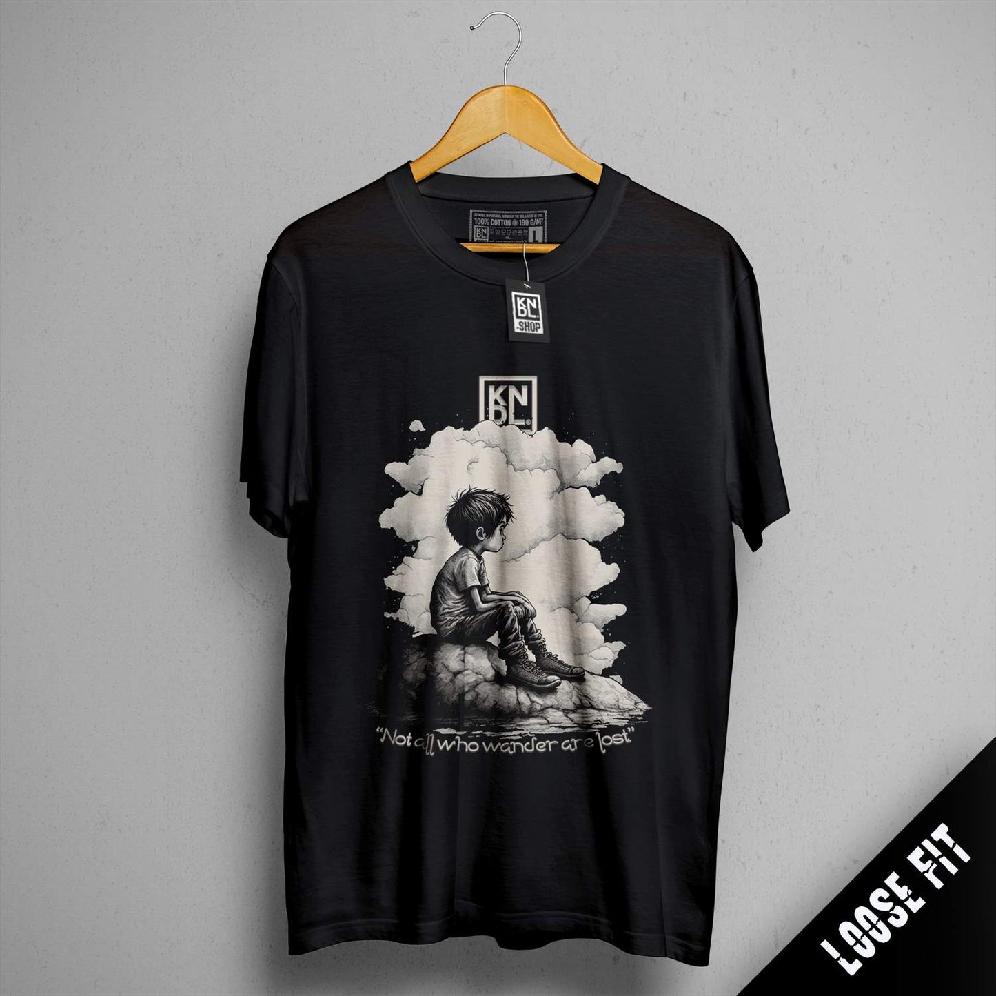 a black t - shirt with a picture of a person sitting on a rock